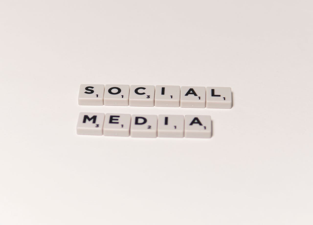 hero-img-02 Scrabble tiles spelling 'social media' on a white background, representing digital communication concepts.