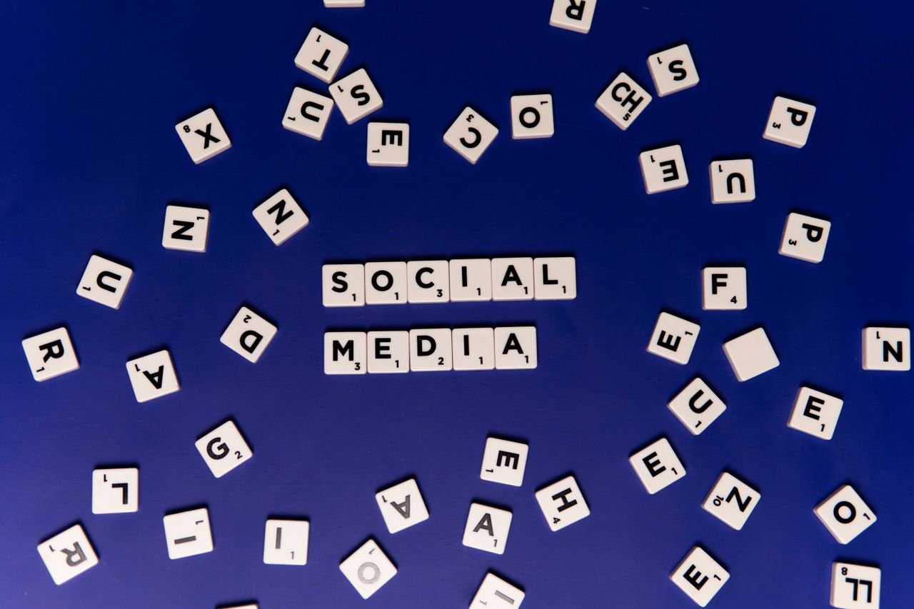 gallery-6 Scrabble tiles spelling 'Social Media' on a blue background, ideal for digital marketing themes.