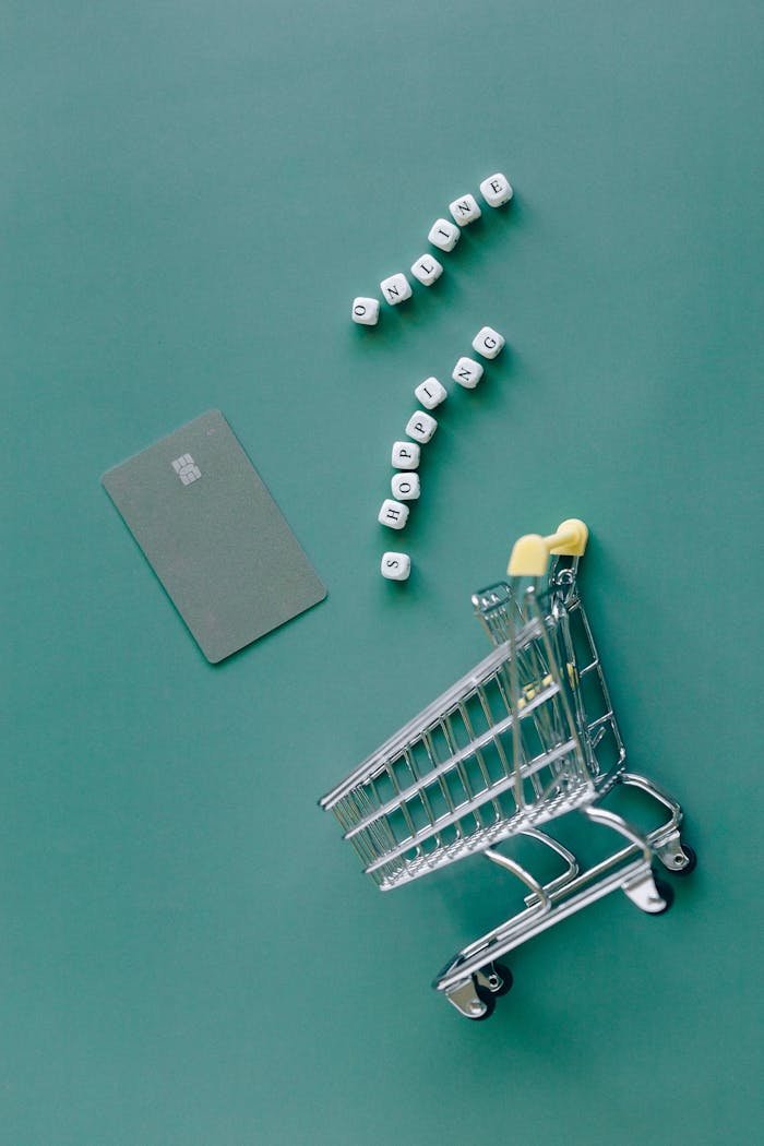 gallery-3 A conceptual image featuring a mini shopping cart, credit card, and letter blocks spelling 'online shopping' on a green background.